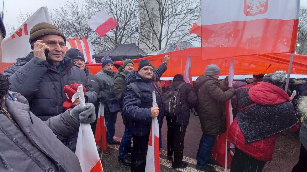 Autor artykułu przy długiej fladze z Marszu Niepodległości.