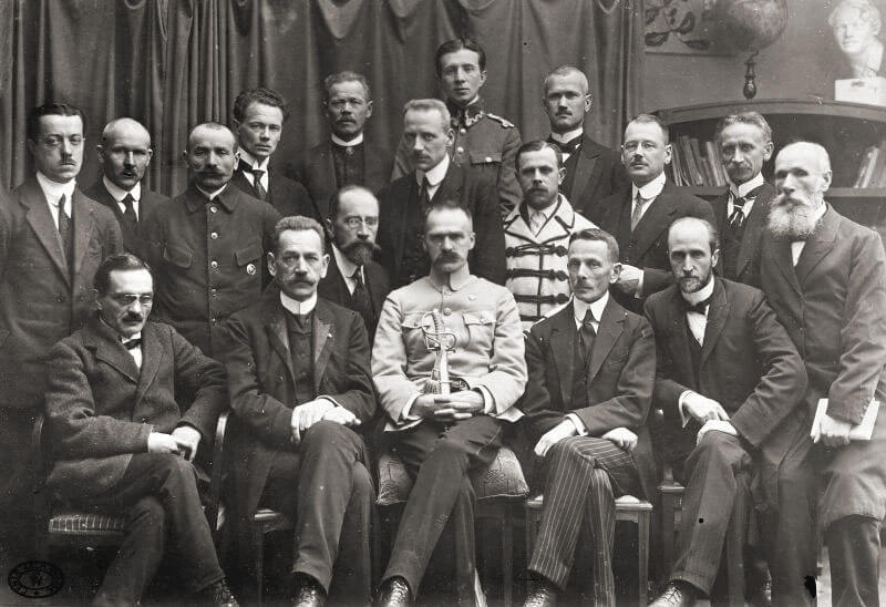 Tymczasowy Rząd Ludowy Republiki Polskiej (rząd Jędrzeja Moraczewskiego). Od lewej siedzą: S. Thugutt, J. Moraczewski, J. Piłsudski, L. Supiński, L. Wasilewski. Na licencji Wikimedia Commons.