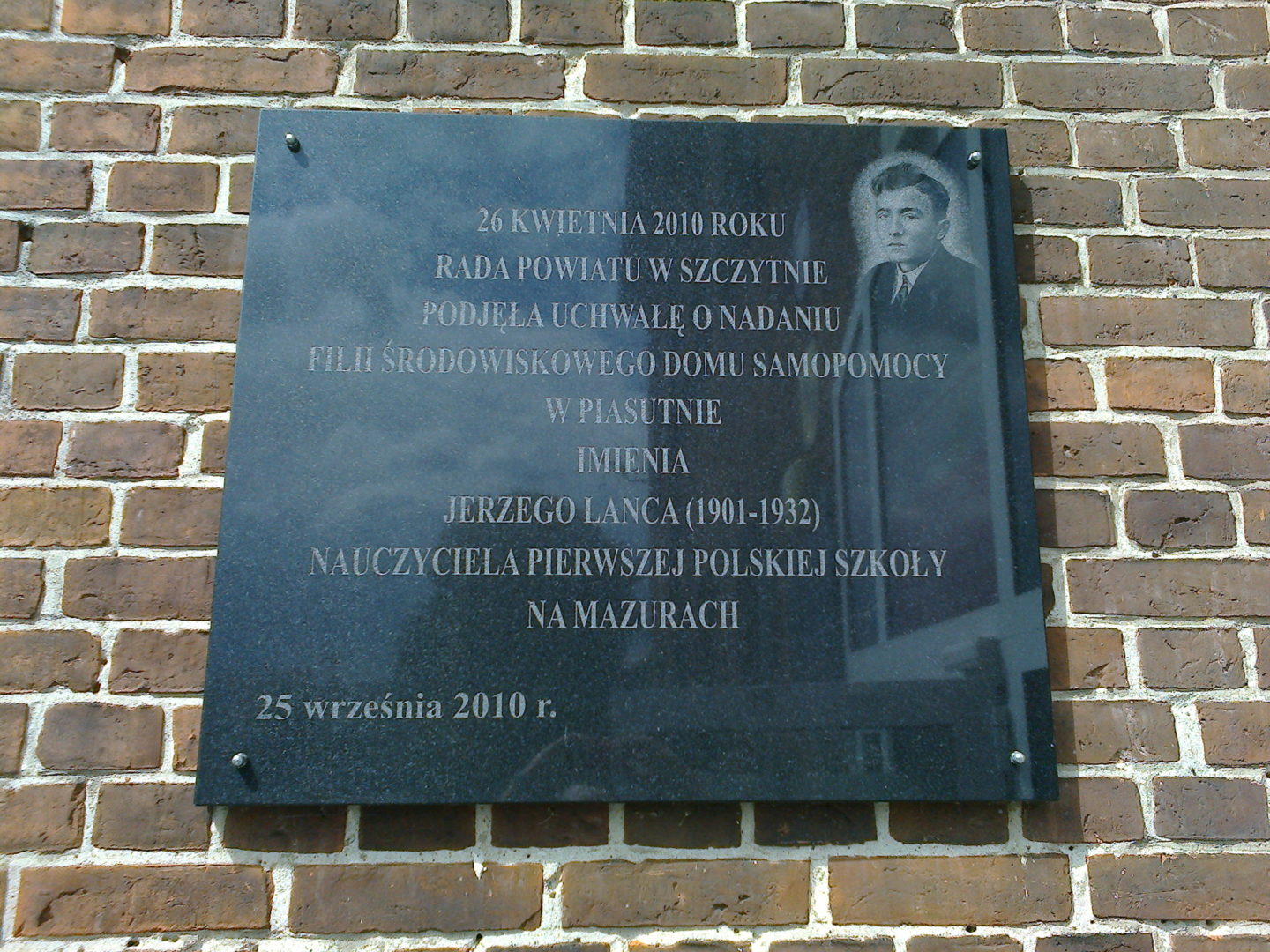 Tablice upamiętniające Jerzego Lanca na budynku szkolnym w Piasutnie